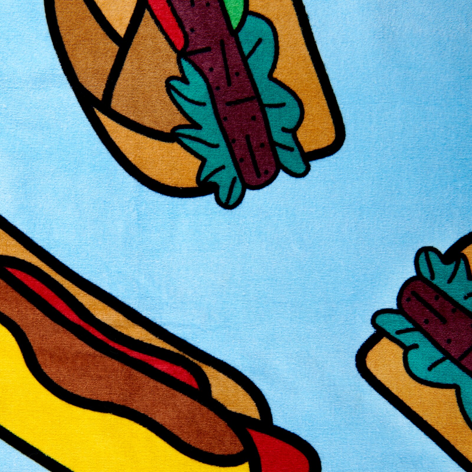 Kleurrijke veloursdoek met hotdog-motief op een lichtblauwe achtergrond, gefotografeerd vanuit vogelperspectief.