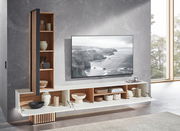 Moderne Wandkombination mit offenen Regalen und geschlossenen Fächern, dekoriert mit Keramik und Körben, neben einem großen Fernseher an einer grauen Wand. Perspektive von schräg vorne.