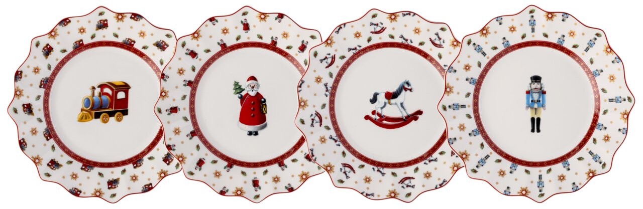 Vier feestelijke jubileumborden met kerstmotieven: een locomotief, een kerstman, een hobbelpaard en een notenkraker. De borden zijn van porselein, hebben een decoratieve rand en zijn versierd met kerstmotieven. Aanzicht van bovenaf.