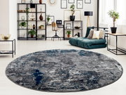 Runder Designer Teppich in Grau- und Blautönen in einem modernen Wohnzimmer mit Blick auf ein Regal und eine gemütliche Sitzecke.