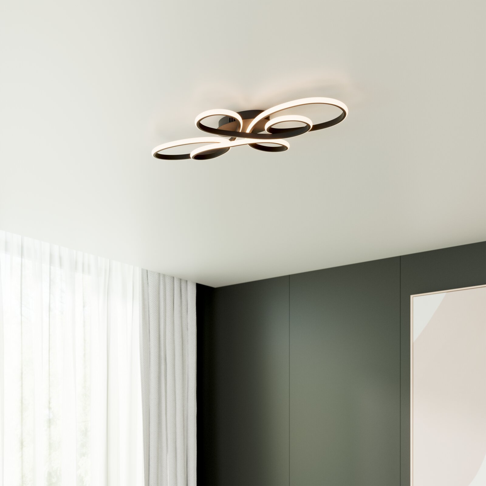 Novel LED-plafondlamp Moderne LED-Deckenleuchte in geschwungener Loop-Form mit warmweiß leuchtenden Lichtbändern, an weißer Zimmerdecke montiert, Ansicht von unten im Raum