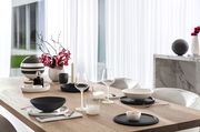 Eleganter Esstisch mit modernem Geschirrset, darunter Whisky Tumbler, in einem stilvollen, hellen Raum mit Blick auf den Garten.