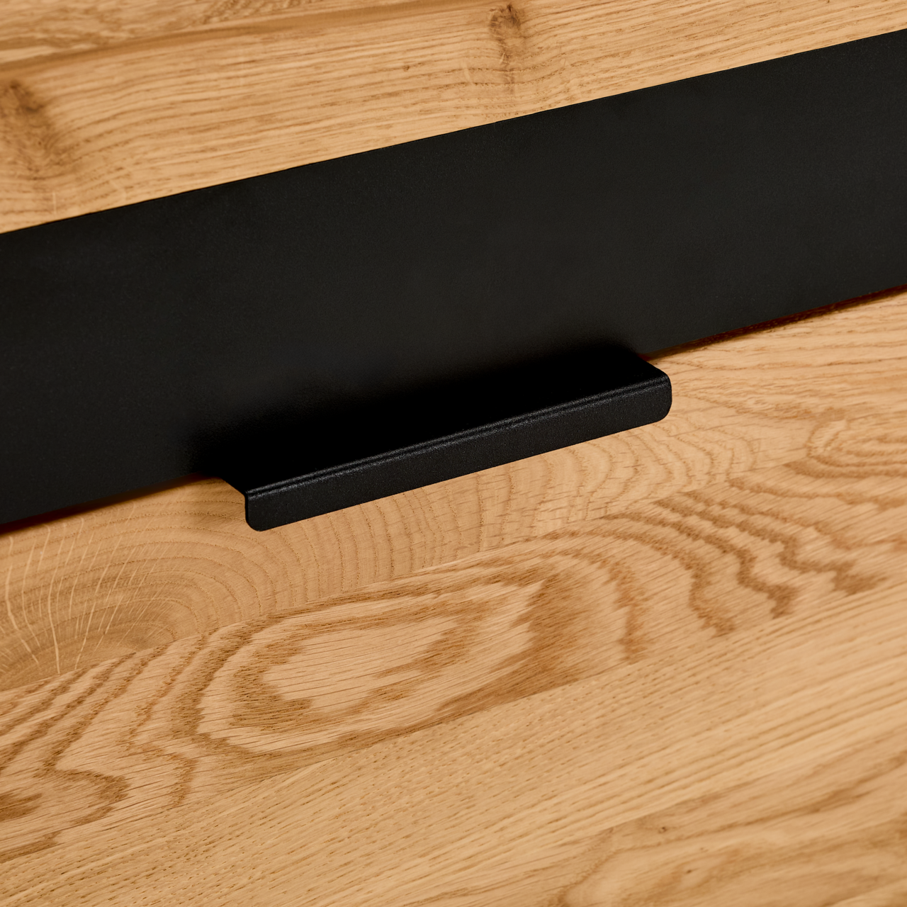 Nahaufnahme eines Sideboards mit Holzmaserung und schwarzem Griff, Perspektive von vorne.