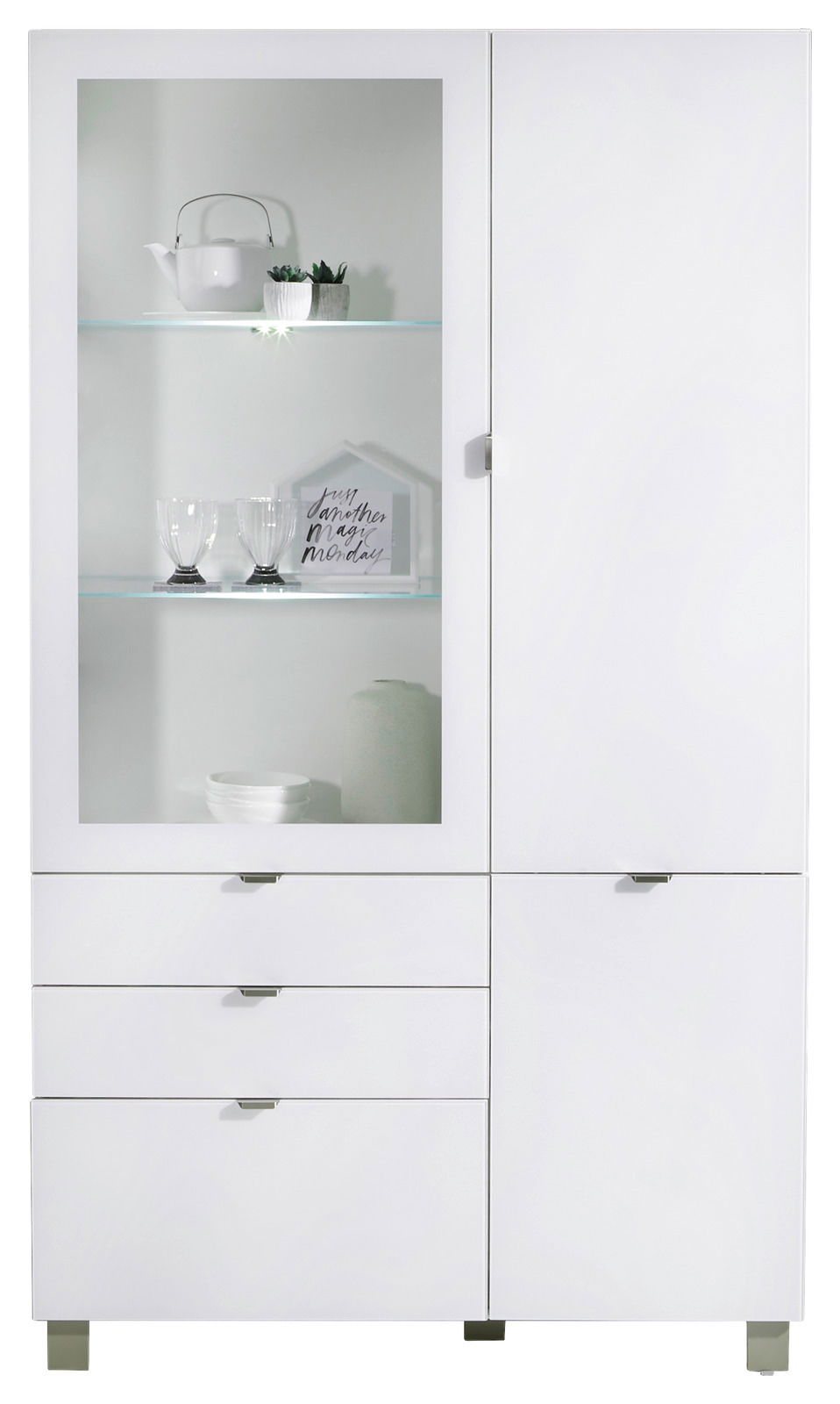Weiße Vitrine mit Glastür und mehreren Schubladen, frontal fotografiert. Dekoriert mit Teekanne, Gläsern und Pflanzen.