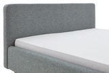 Seitliche Ansicht eines grauen Polsterbettgestells mit Kopfteil.