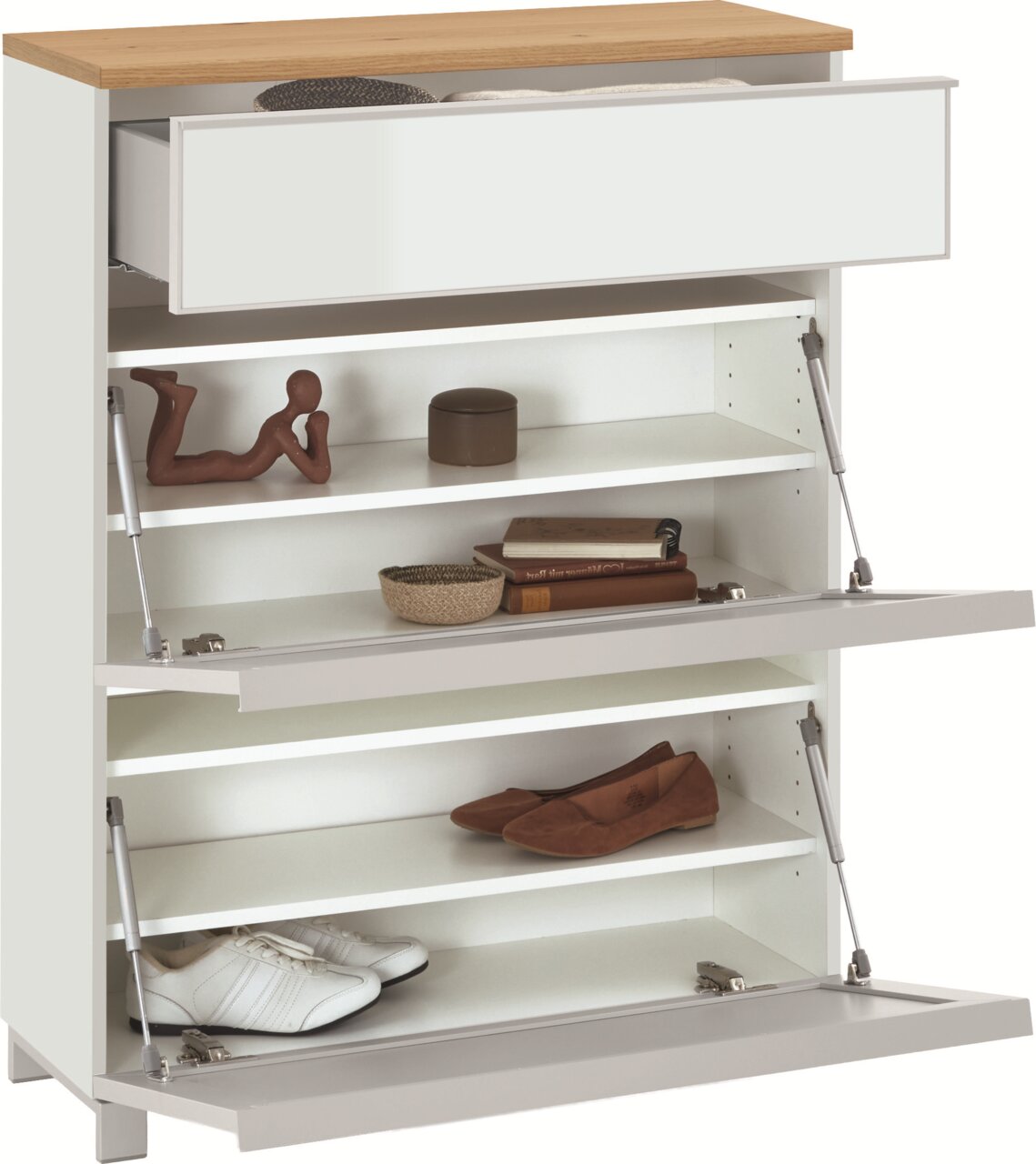Weißer Schuhschrank mit Holzoptik-Deckplatte, geöffneter Schublade und zwei nach vorn aufgeklappten Klappen mit Einlegeböden und Schuhen, Ansicht schräg von vorn.