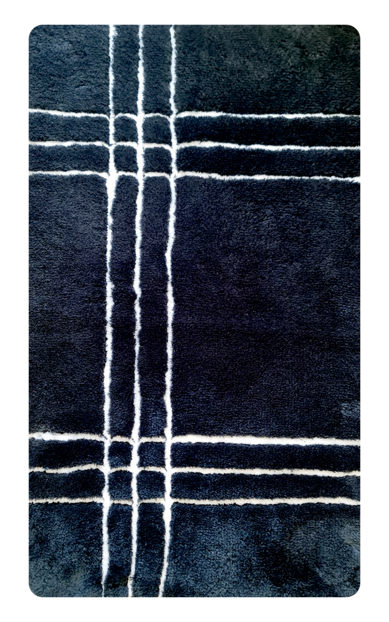 Draufsicht auf einen dunkelblauen Badteppich mit weißen Linien im Karomuster.