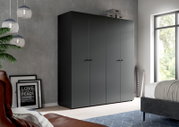 Moderner, mattgrauer Kleiderschrank mit vier Türen und minimalistischen Griffen im Schlafzimmer, schräg von vorne aus leicht linker Perspektive fotografiert.