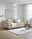 Beige Querschläfer-Sofa mit Hubbeschlag in einem modernen Wohnzimmer, seitliche Perspektive. Dekoriert mit Kissen und einer Decke, daneben ein runder Beistelltisch und eine Stehlampe.
