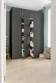 Moderner Apothekerschrank in dunklem Design mit geöffneten Türen, gefüllt mit Haushaltsartikeln, aus der Perspektive eines hellen Raumes betrachtet.