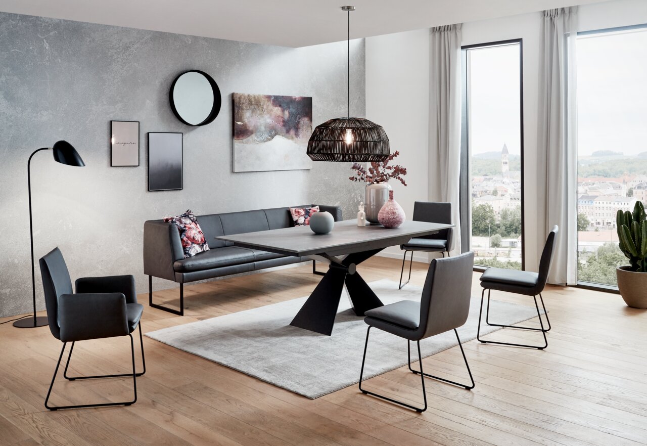 Moderner Esstisch mit X-förmigem Gestell in einem stilvollen Esszimmer mit Blick auf die Stadt.