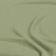 Nahaufnahme eines grünen Spannbetttuchs mit weicher Textur.