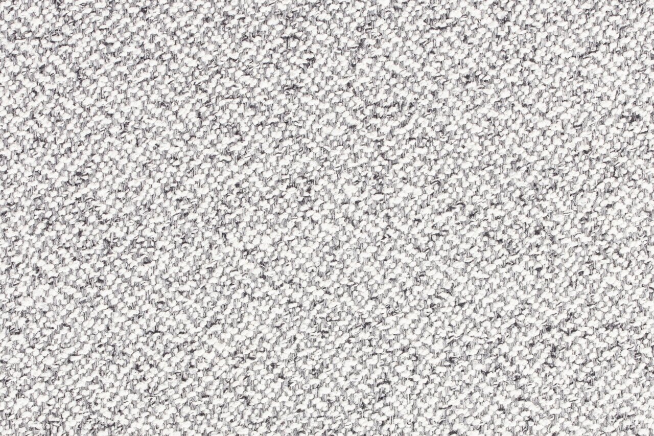 Nahaufnahme einer grauen, strukturierten Stoffoberfläche in Draufsicht