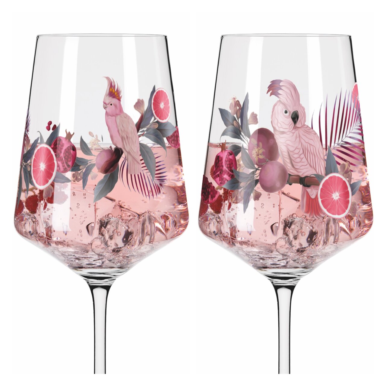 Twee wijnglazen met een tropisch ontwerp, versierd met roze kaketoes, granaatappels en grapefruits, gevuld met een roze drankje en ijsblokjes, gezien vanuit de zijkant.