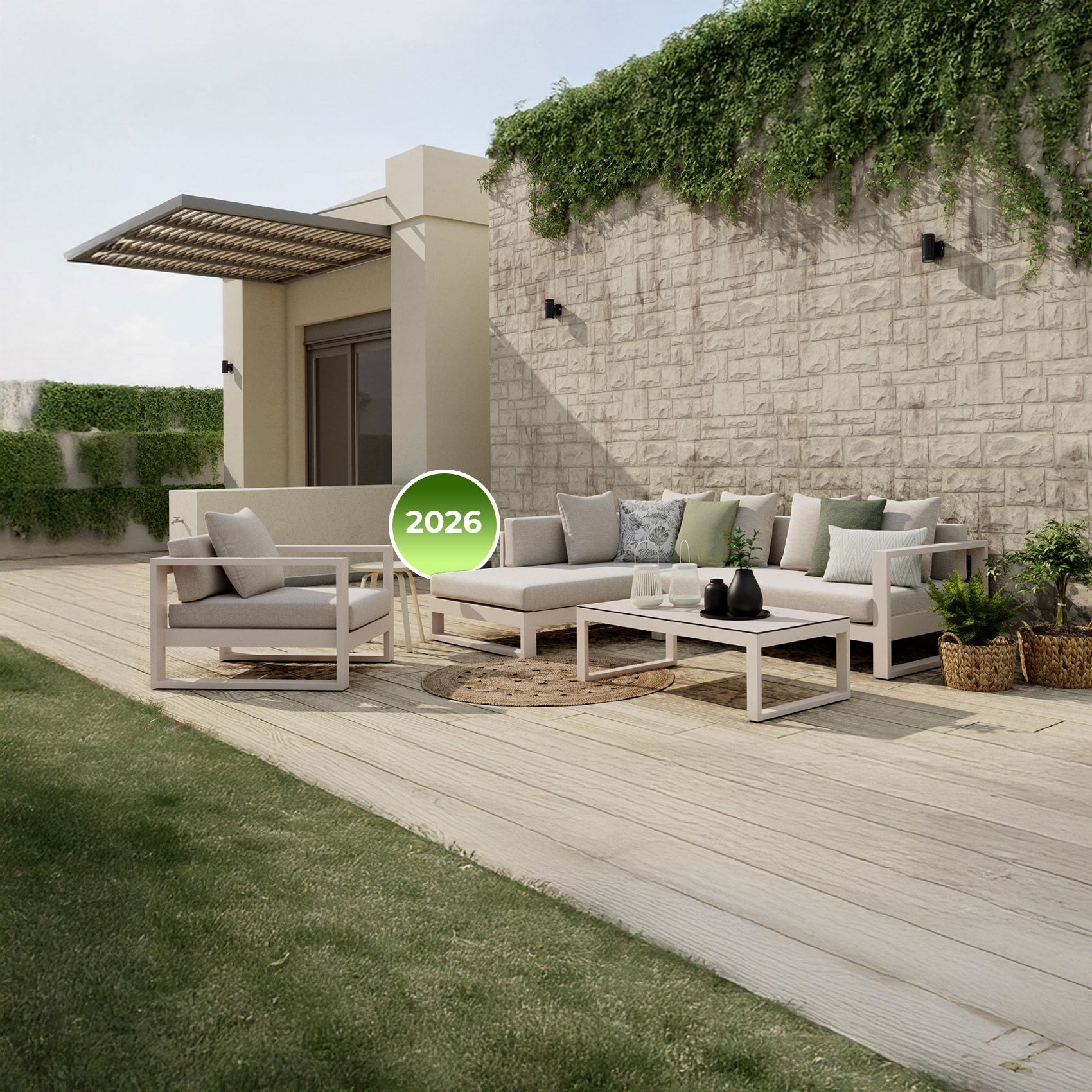 Moderne Terrasse mit hellen Loungemöbeln, Holzdeck und begrüntem Steinwall, Label „2026“ im Vordergrund