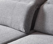 Nahaufnahme einer grauen Longchairkombination mit strukturierter Stoffoberfläche, seitliche Perspektive.