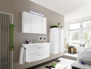 Moderne Badkombination in einem hellen Badezimmer mit Wandspiegel, Waschbeckenunterschrank und Hochschränken, seitliche Perspektive.