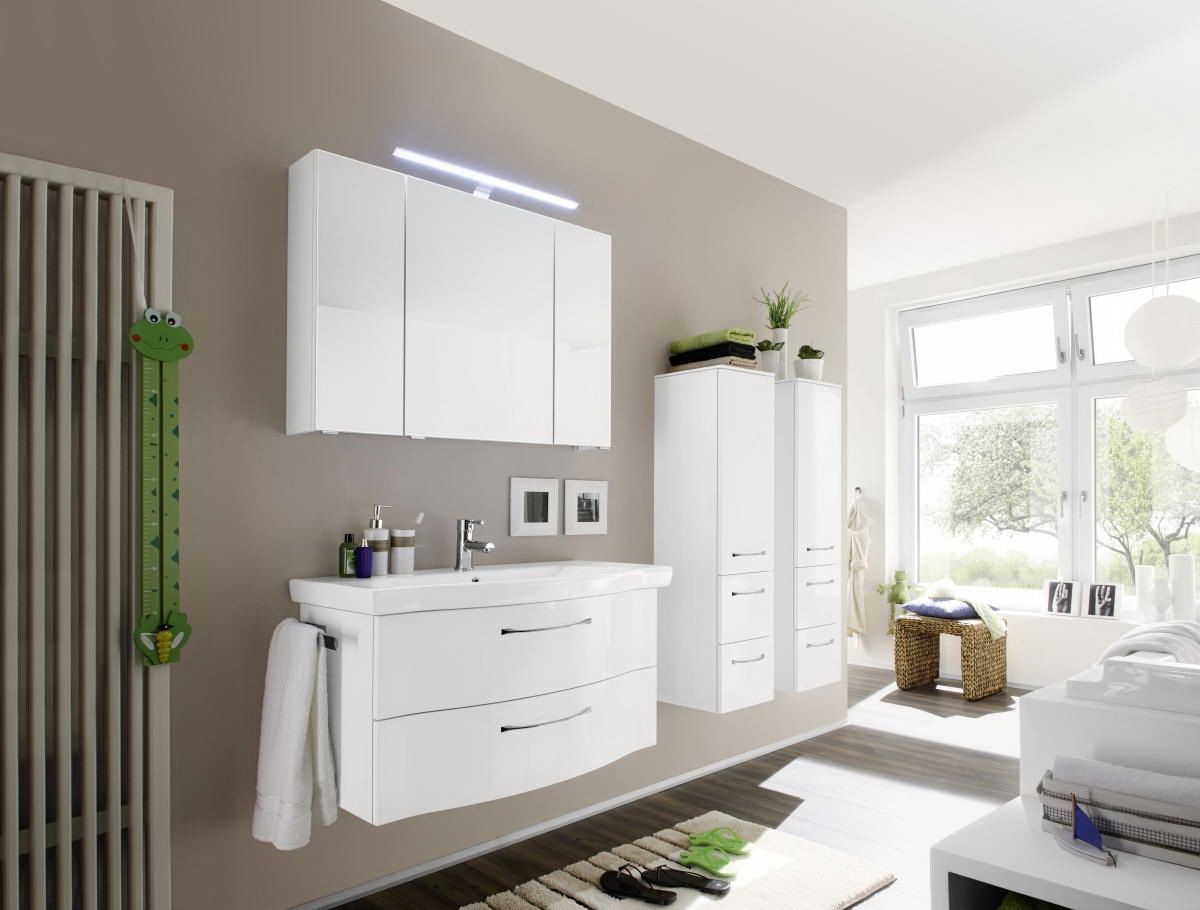 Moderne Badkombination in einem hellen Badezimmer mit Wandspiegel, Waschbeckenunterschrank und Hochschränken, seitliche Perspektive.