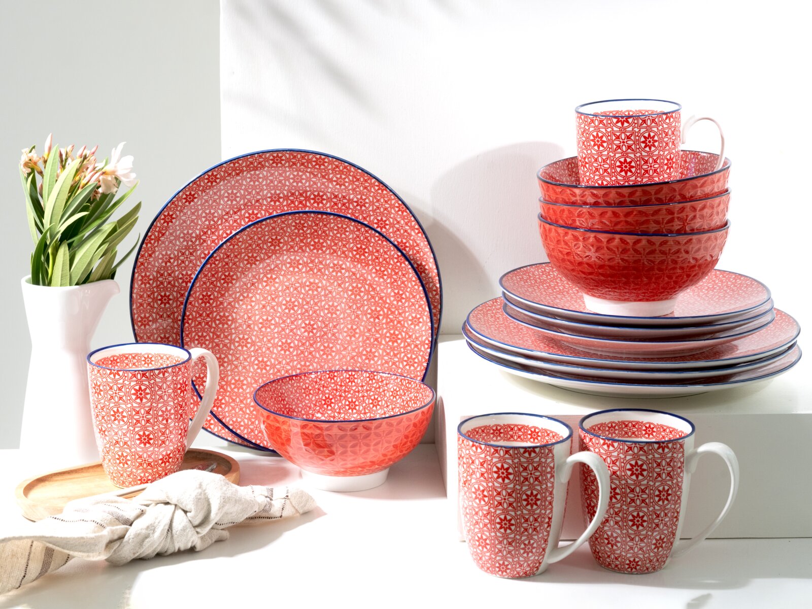 Creatable Kombiservice 16-tlg MEDITERRAN Rot-weiß gemustertes Geschirrset mit Tellern, Schalen und Tassen, blauem Rand und geometrischem Ornament, dekorativ gestapelt auf weißem Hintergrund; Perspektive: leicht schräg von vorne in Augenhöhe
