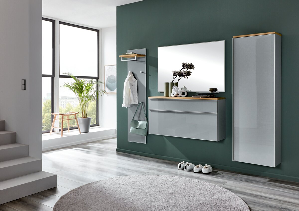 Modernes Garderoben-Set im Flur mit grauen Hochglanz-Wandmöbeln und Holzablagen, bestehend aus Spiegel, Hängekommode, Garderobenpaneel und Hochschrank; Perspektive: frontale Ansicht leicht von links.