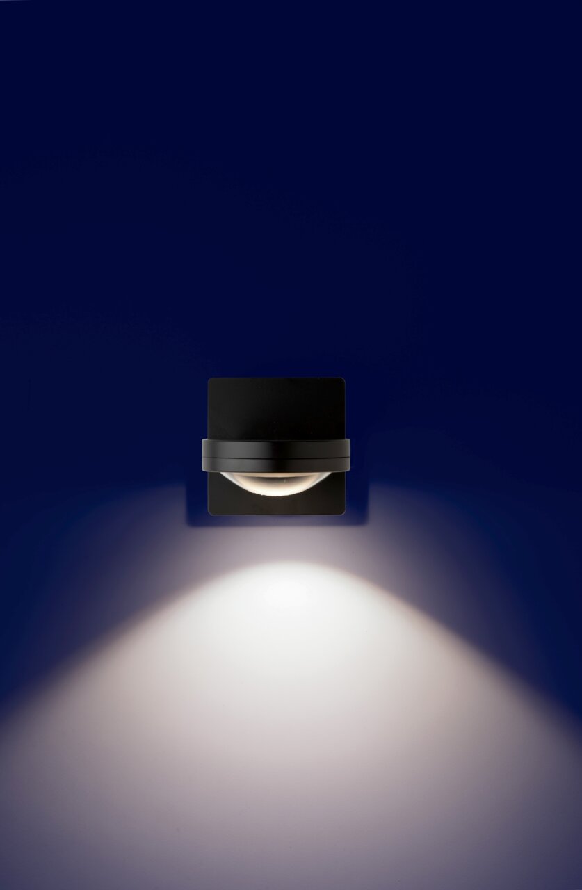 LED Wandleuchte in schwarzem Design, frontal an einer Wand montiert, mit nach unten gerichteter Lichtstrahlung.