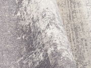 Nahaufnahme eines Designer Teppichs mit grauem und weißem Muster, perspektivisch von der Seite aufgenommen.