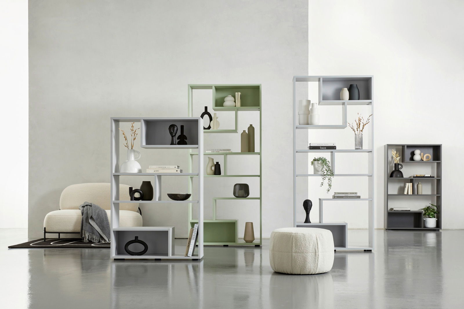 Moderne Raumteiler in verschiedenen Farben und Größen, dekoriert mit Vasen und Büchern, in einem hellen, minimalistischen Raum. Perspektive von vorne.