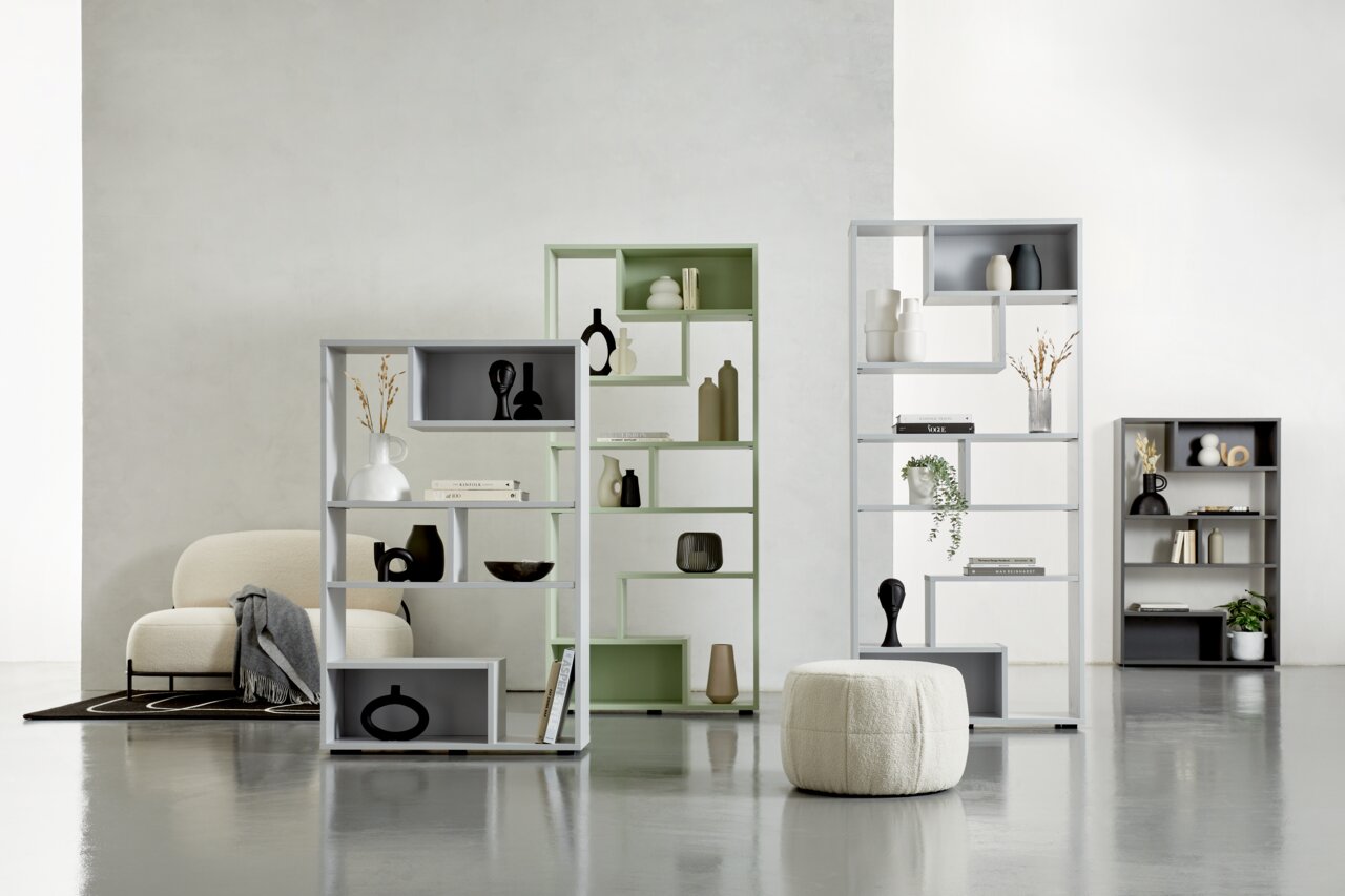 Moderne Raumteiler in verschiedenen Farben und Größen, dekoriert mit Vasen und Büchern, in einem hellen, minimalistischen Raum. Perspektive von vorne.