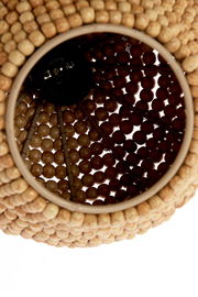 Nahaufnahme einer Hängeleuchte aus Holzperlen, von unten betrachtet.