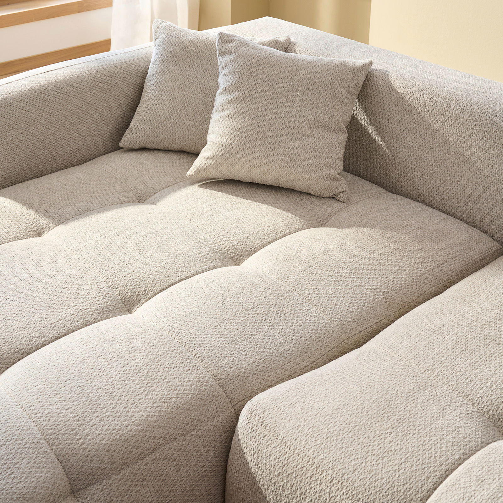 Nahaufnahme eines beigen Ecksofas mit Kissen, Perspektive von oben