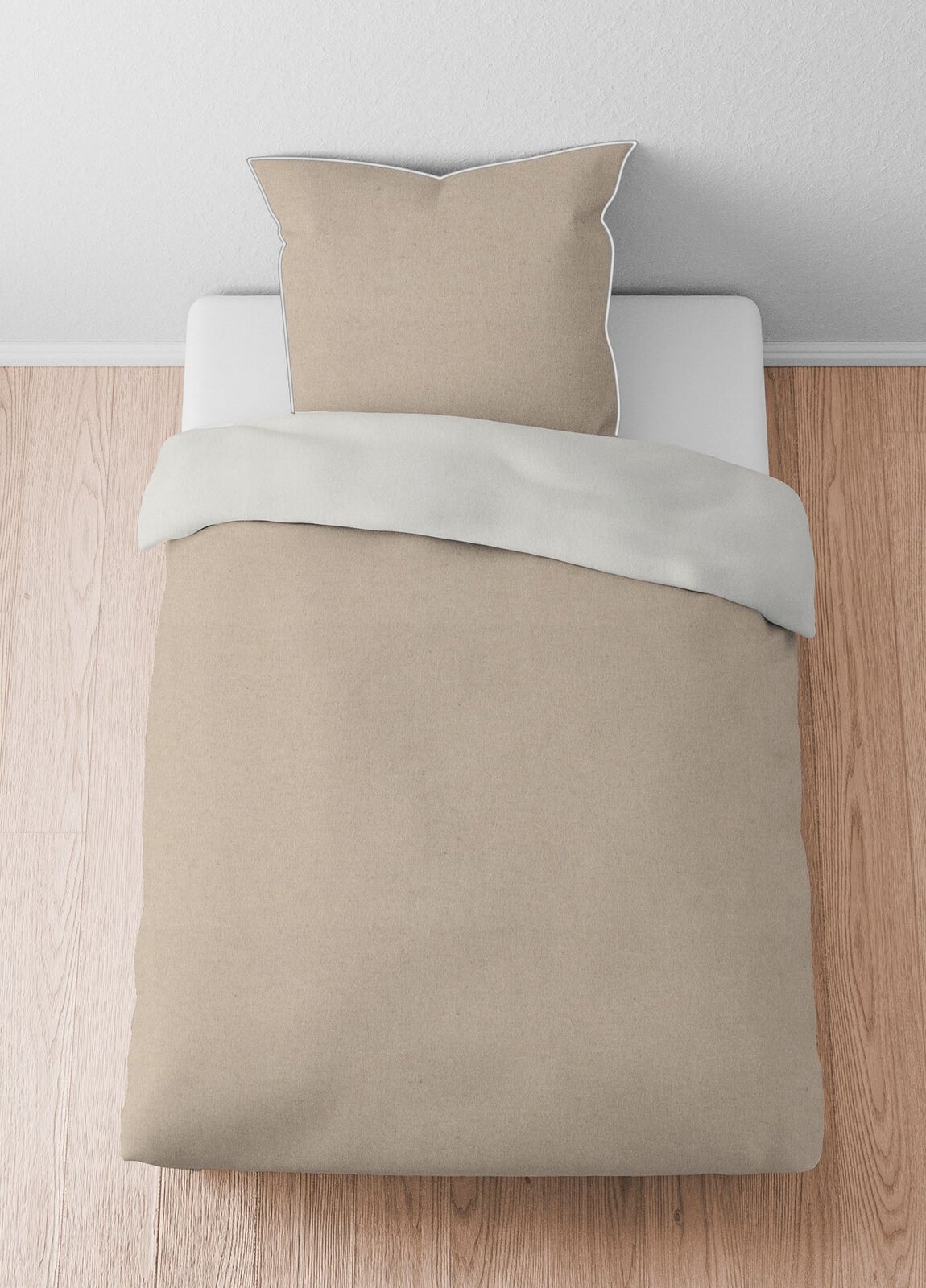 Bettwäsche-Set aus Melange-Flanell in Beige, bestehend aus einem Kissenbezug und einem Bettdeckenbezug, von oben fotografiert auf einem Holzboden.