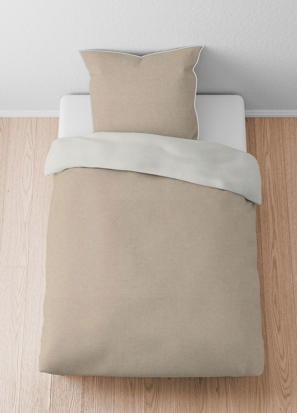 Bettwäsche-Set aus Melange-Flanell in Beige, bestehend aus einem Kissenbezug und einem Bettdeckenbezug, von oben fotografiert auf einem Holzboden.