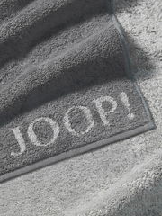 Graues Handtuch von JOOP! mit eingewebtem Logo, Nahaufnahme der Textur und Kanten.