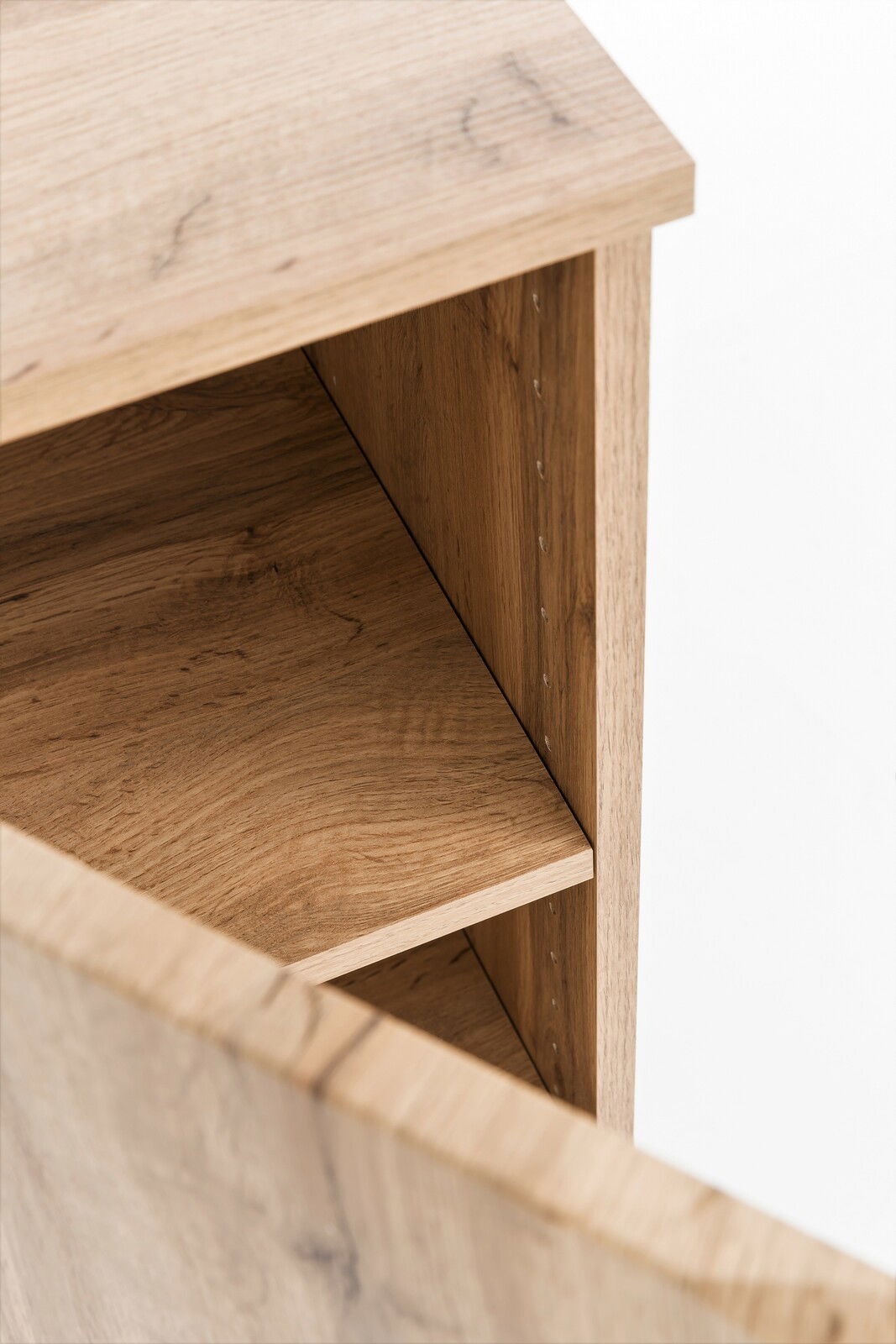 Nahaufnahme eines offenen Midischranks aus Holz mit sichtbaren Regalböden, Perspektive von oben.