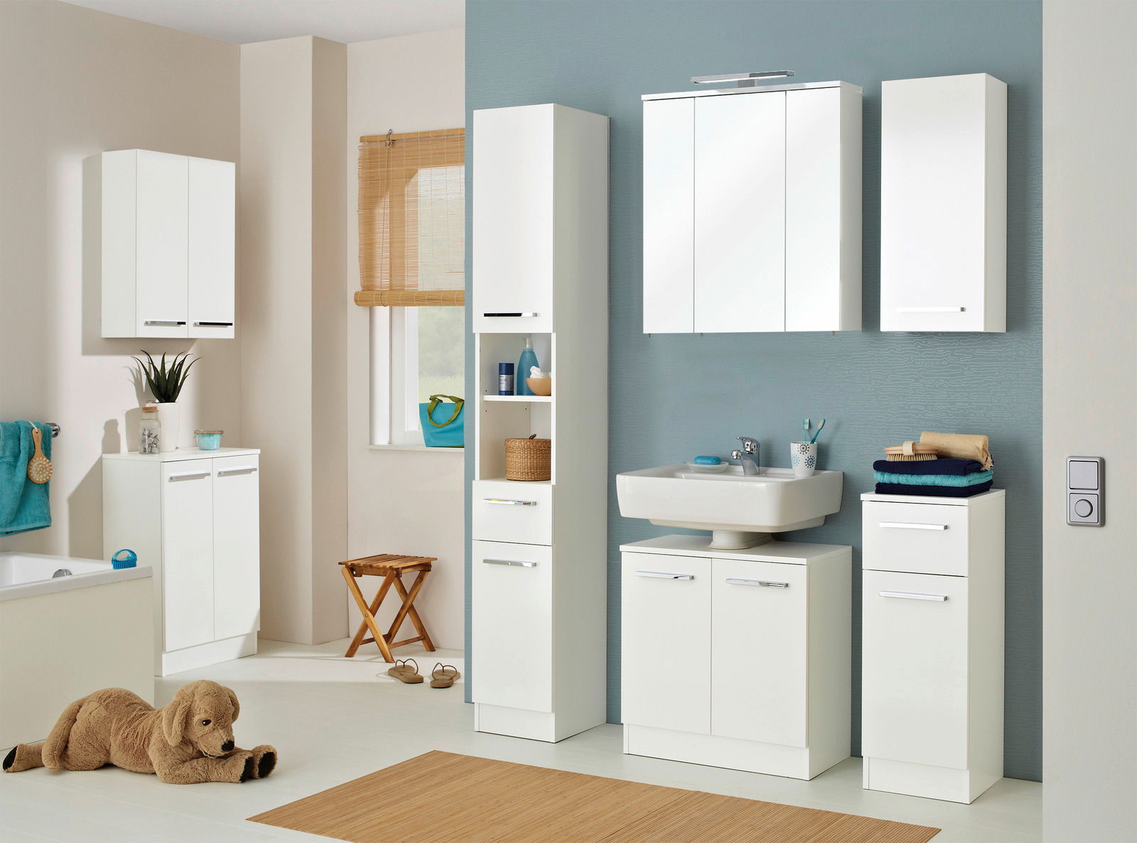 Moderne Badezimmermöbel in Weiß, bestehend aus einem Waschbeckenunterschrank, einem Hochschrank, einem Spiegelschrank und einem Wandschrank, aus der Frontalperspektive betrachtet.