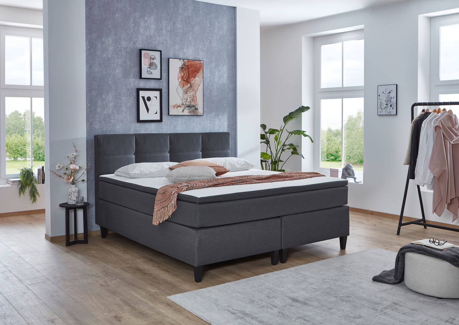 Modernes Boxspringbett in einem stilvoll eingerichteten Schlafzimmer, seitliche Perspektive