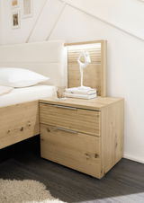 Nachttisch aus Holz mit zwei Schubladen, dekoriert mit einer weißen Skulptur und Büchern, seitliche Perspektive