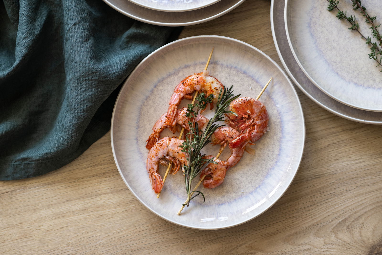 Speiseteller mit Garnelenspießen und Kräutern, von oben fotografiert