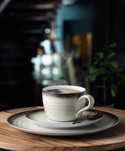 Kaffeeservice mit Tasse, Untertasse und Teller in stilvollem Design, seitliche Perspektive