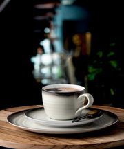 Kaffeeservice mit Tasse, Untertasse und Teller in stilvollem Design, seitliche Perspektive