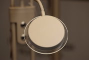 Runde, beige LED-Schreibtischlampe mit flexiblem Schwanenhals, Nahaufnahme von oben auf den Lampenkopf