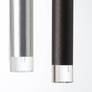 Nahaufnahme von zwei zylindrischen LED-Leuchten in Schwarz und Silber mit klaren Endkappen, seitliche Perspektive.