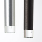 Nahaufnahme von zwei zylindrischen LED-Leuchten in Schwarz und Silber mit klaren Endkappen, seitliche Perspektive.