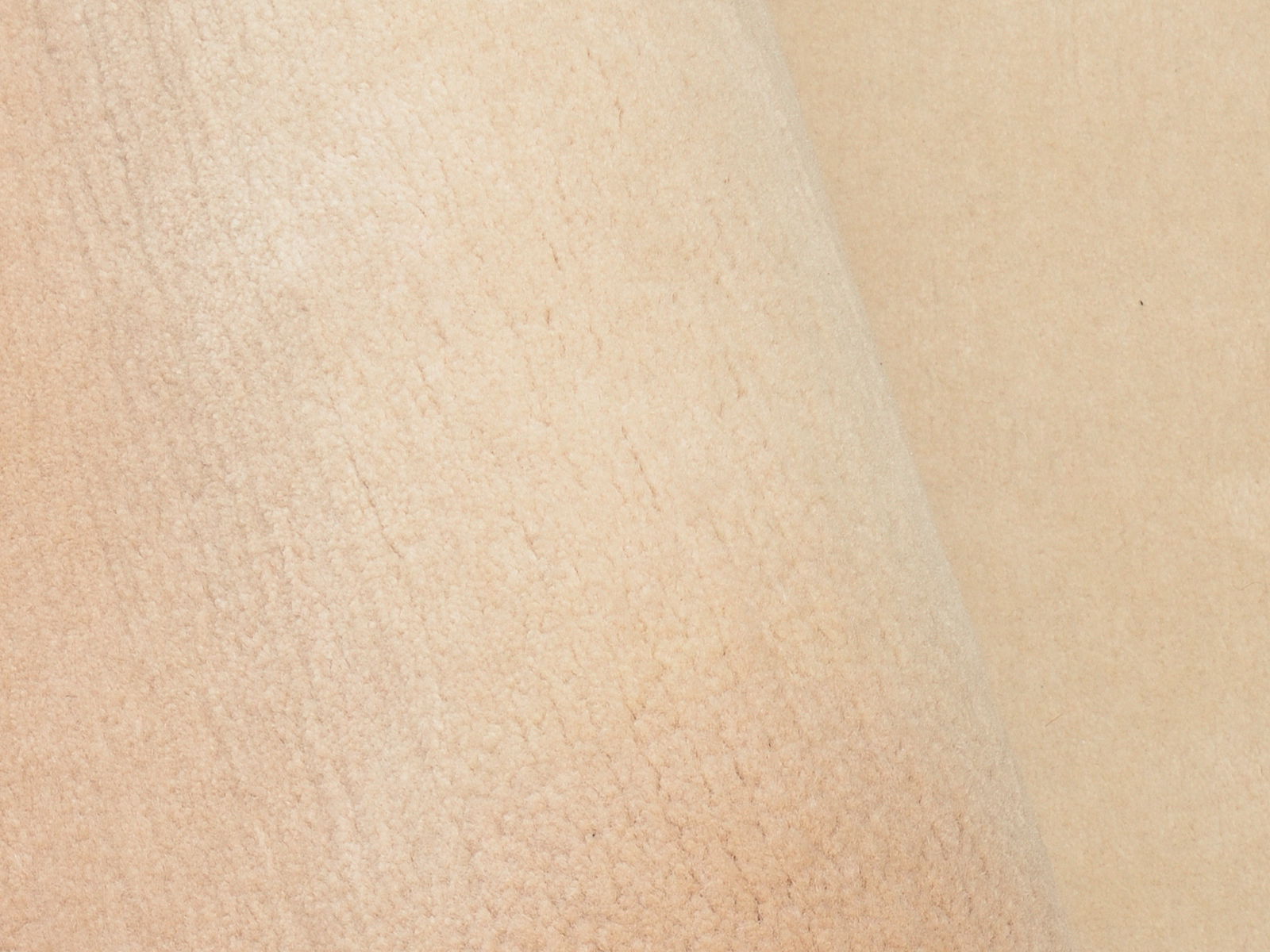 Nahaufnahme eines beigen Wollteppichs mit weicher Textur