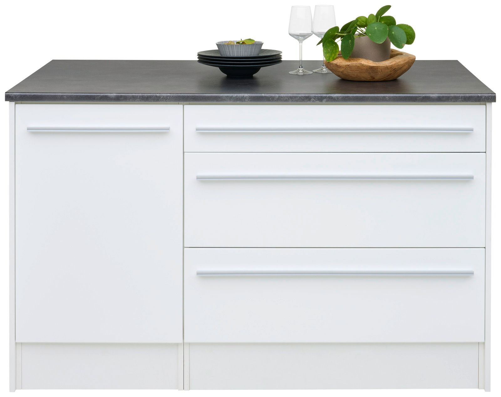 Weiße Kücheninsel mit dunkler Arbeitsplatte, zwei Weingläsern, einem Holztablett mit Pflanze und einem Stapel schwarzer Teller, frontale Ansicht.