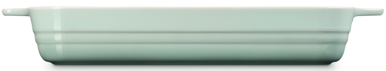 Mintgroene, ovale ovenschaal van keramiek met handvatten aan de zijkant, zijaanzicht op een witte achtergrond.