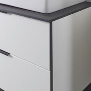 Nahaufnahme eines modernen Waschtisch-Sets mit weißem Korpus und dunkler Arbeitsplatte, seitliche Perspektive