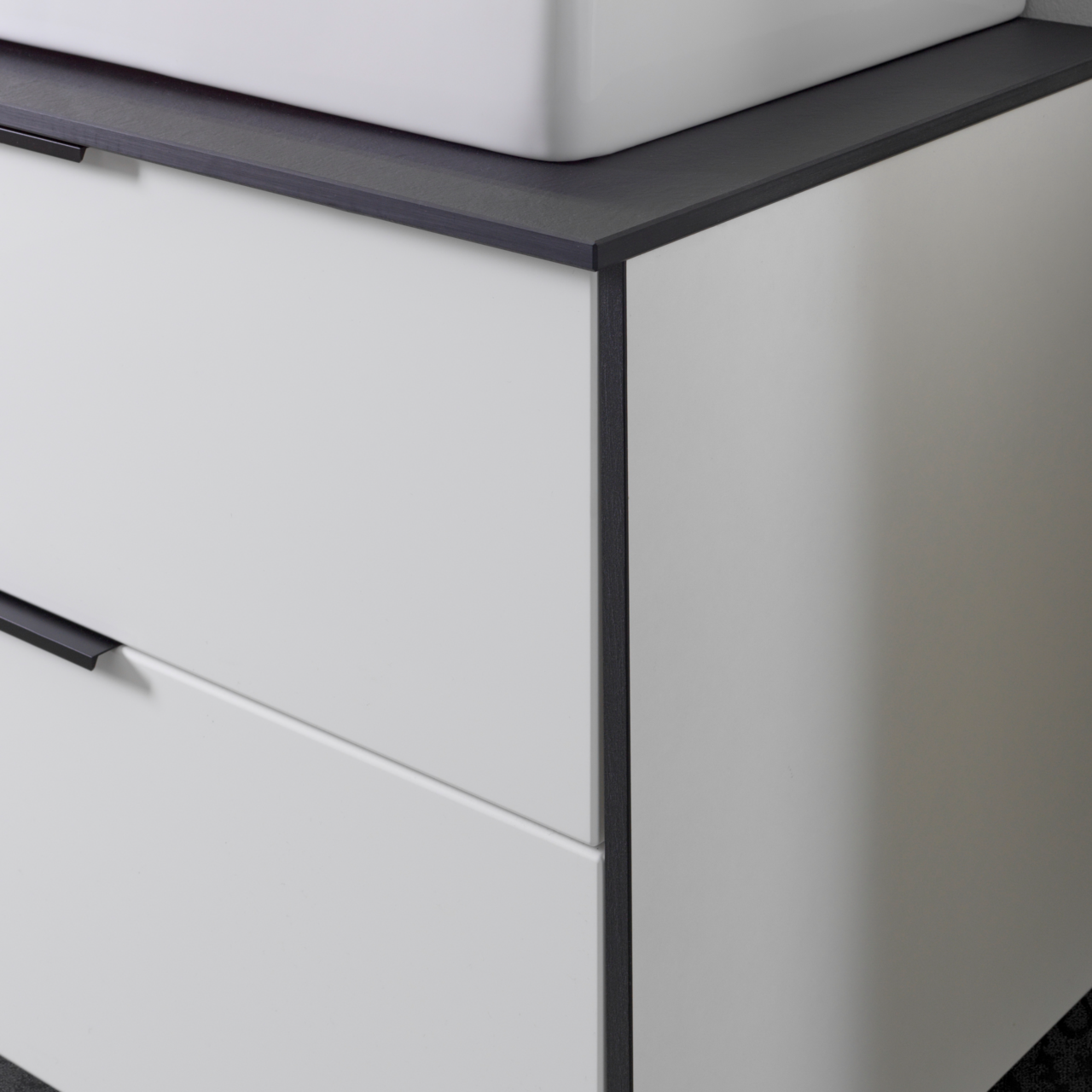 Voleo Waschtisch-Set STELLA Nahaufnahme eines modernen Waschtisch-Sets mit weißem Korpus und dunkler Arbeitsplatte, seitliche Perspektive