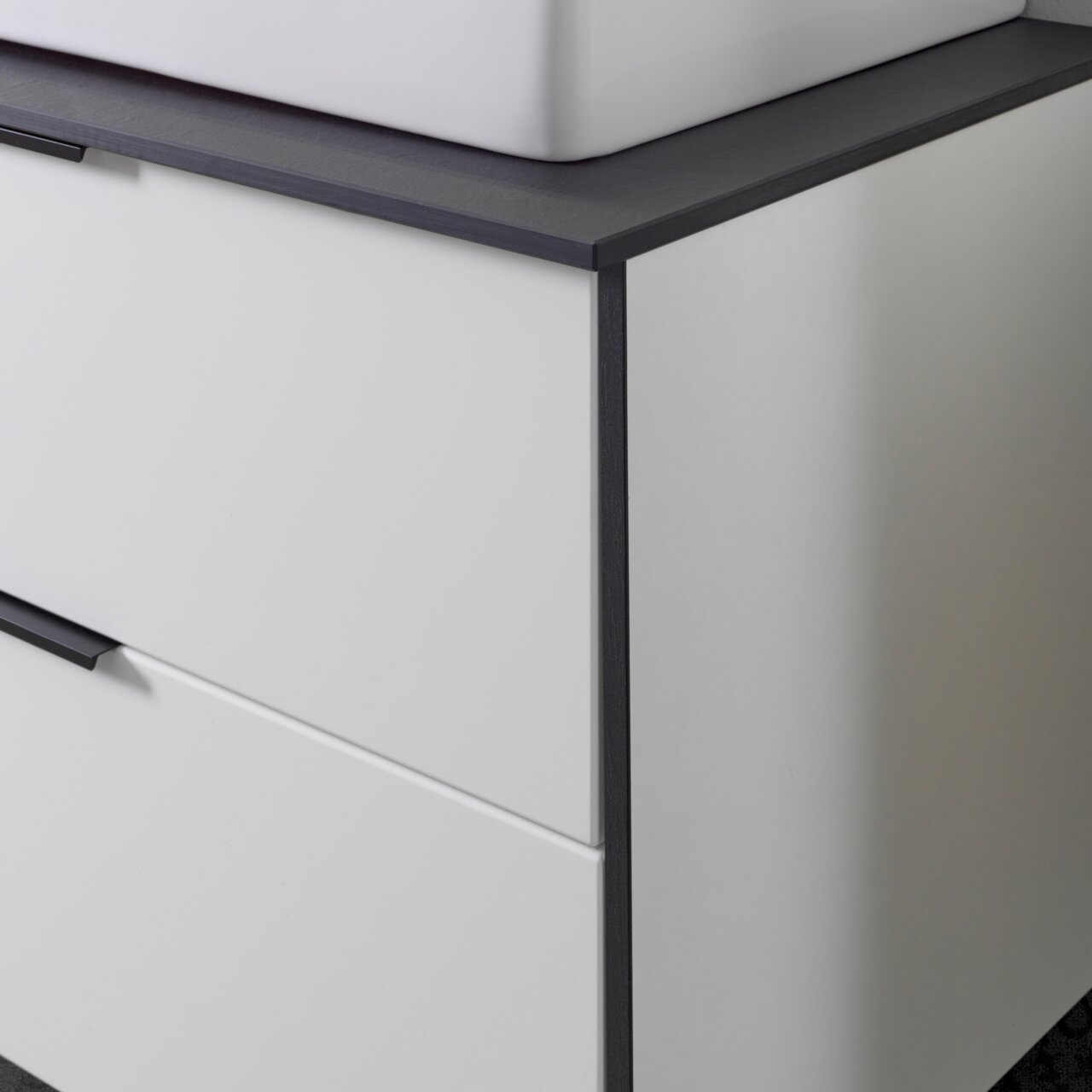 Voleo Waschtisch-Set STELLA Nahaufnahme eines modernen Waschtisch-Sets mit weißem Korpus und dunkler Arbeitsplatte, seitliche Perspektive