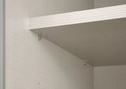 Nahaufnahme eines Schwebetürenschranks mit einem Regalbrett und Metallhalterungen, seitliche Perspektive.